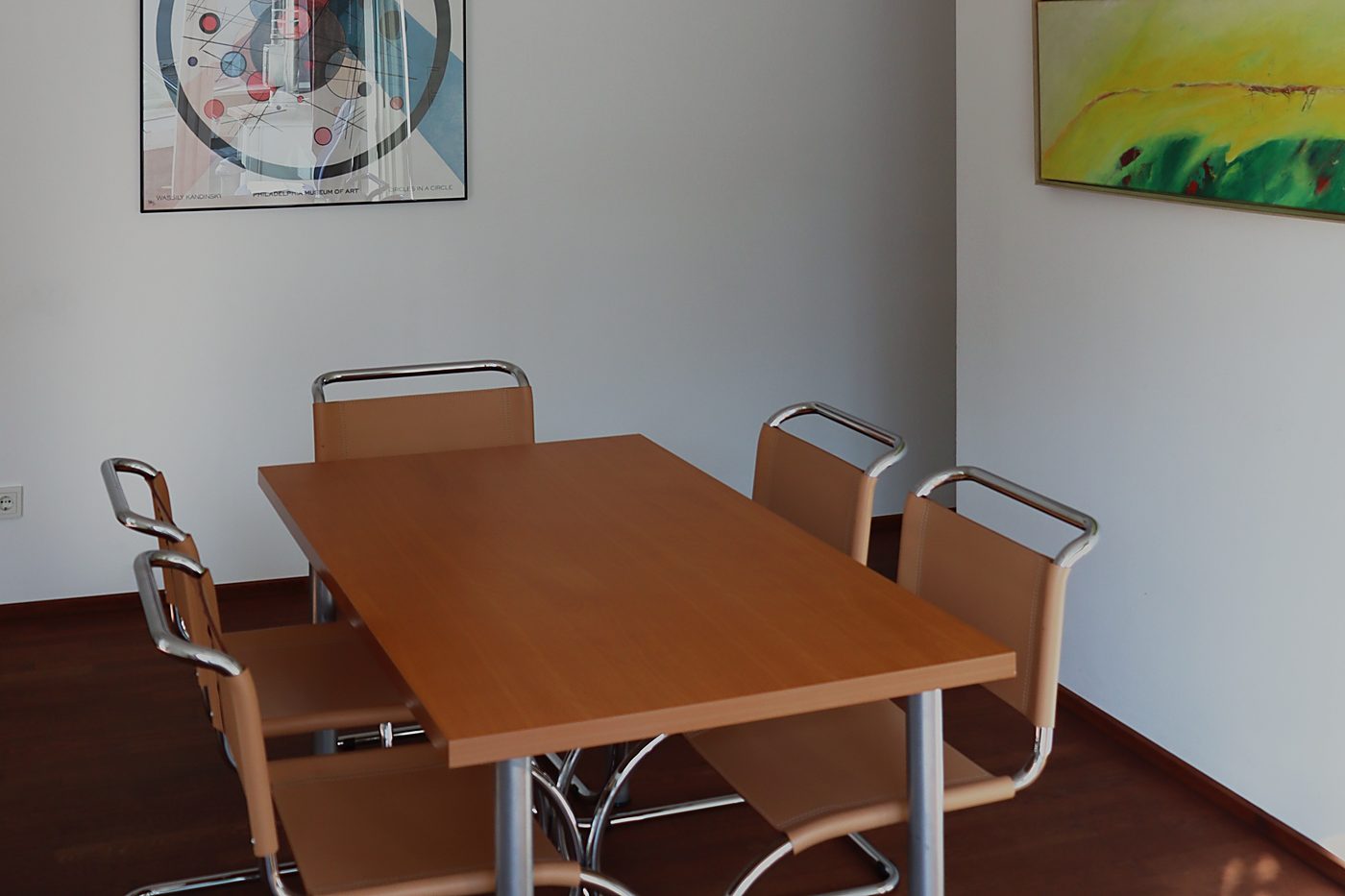 Besprechungstisch im Beratungsraum vor einer hellen Wand mit Bildern