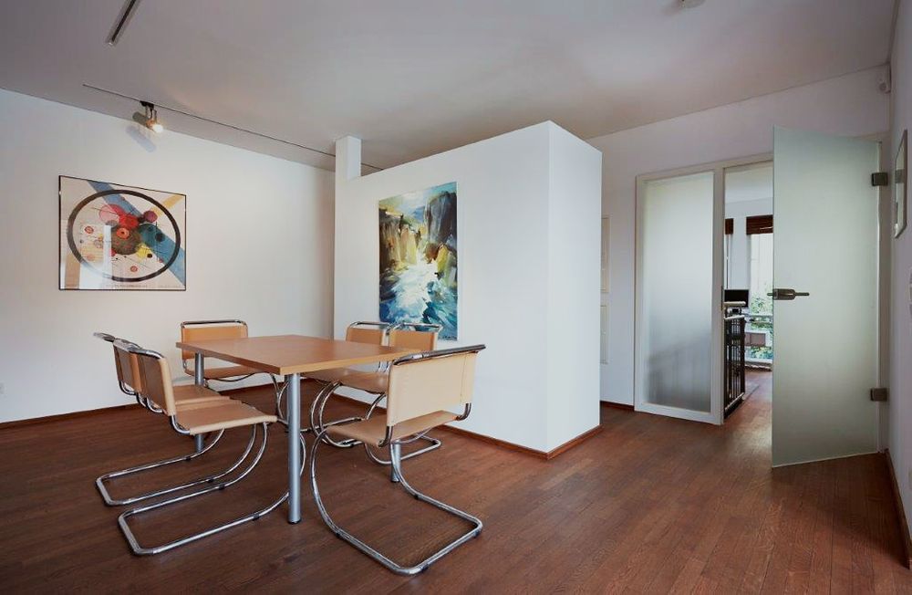 Besprechungsraum mit Tisch, Stühlen und Kunst an den Wänden